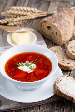 Tasty soup with bread on a wooden background.