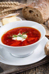 Tasty soup with bread on a wooden background.