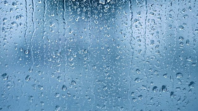 Raindrops on the window. Blue tone
