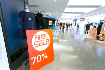 sale poster board at fashion clothes shopfront