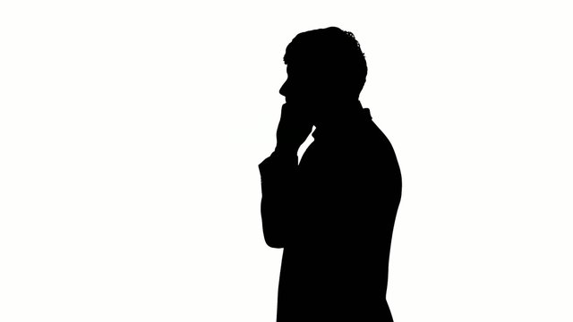 Black silhouette of man typing on mobile telephone