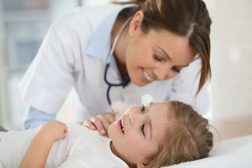 Obraz na płótnie Canvas Doctor checking on child's ear