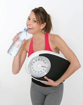 Cheerful fitness girl with bottle of water, isolated
