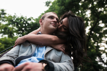 Young European couple cuddling on a park bench