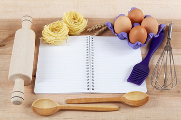 Baking ingredients for cooking and notebook for recipes on a woo