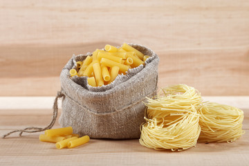 Sack with pasta on a wooden board.