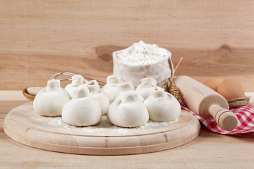 Baking ingredients for cooking manti dumplings on a wooden board
