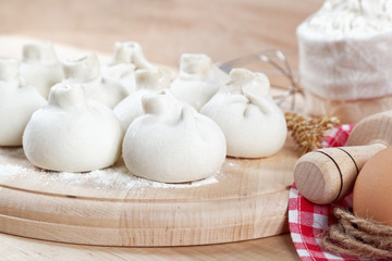 Baking ingredients for cooking manti dumplings on a wooden board