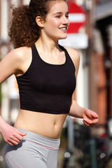 Fototapeta na wymiar Happy teenage girl running outdoors