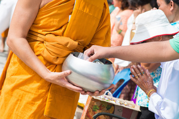 give alms to a Buddhist monk in Songkran Festival