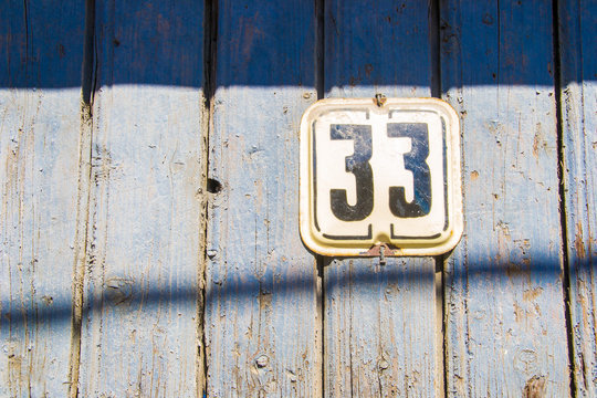 Number 33 on the wooden blue chapped wall