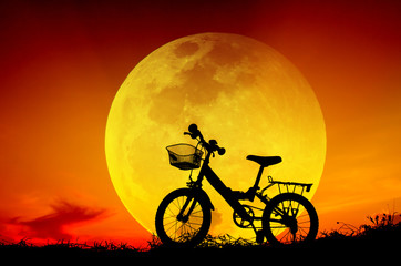 Fototapeta na wymiar Bicycle silhouette with sun set and big moon.