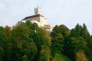 Fototapeta premium Castle on the woody hill, in autumn