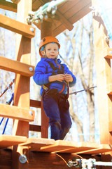 Fototapeta na wymiar little boy climbing in adventure activity park