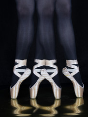 Ballerina -Tänzerin  - Beine mit Spitzenschuhe mit schwarzen Hintergrund