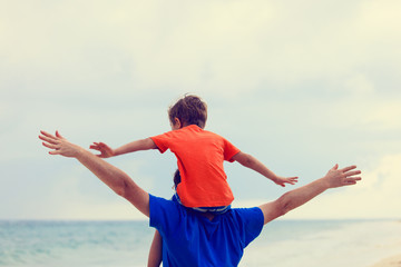 Fototapeta na wymiar happy father and son playing on sea beach