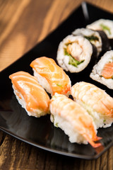 Sushi pieces collection with bamboo chopsticks, isolated on wooden table