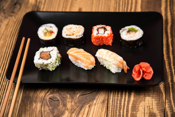 Sushi pieces collection with bamboo chopsticks, isolated on wooden table