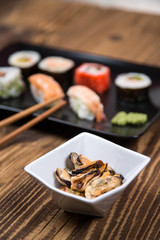 Sushi pieces collection with bamboo chopsticks, isolated on wooden table