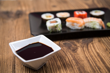Sushi pieces collection with bamboo chopsticks, isolated on wooden table