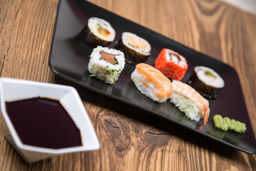 Sushi pieces collection with bamboo chopsticks, isolated on wooden table