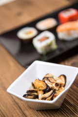 Sushi pieces collection with bamboo chopsticks, isolated on wooden table