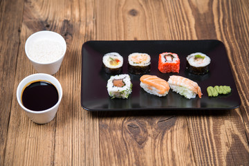 Sushi pieces collection with bamboo chopsticks, isolated on wooden table