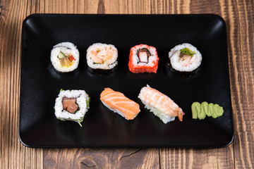 Sushi pieces collection with bamboo chopsticks, isolated on wooden table