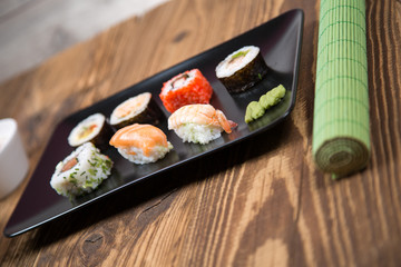 fresh Japanese tasty sushi roll set with chopsticks on wooden table