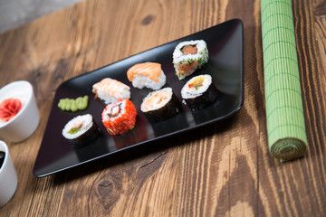 fresh Japanese tasty sushi roll set with chopsticks on wooden table