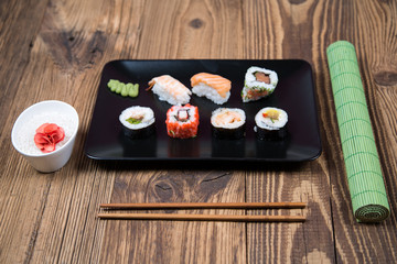 fresh Japanese tasty sushi roll set with chopsticks on wooden table