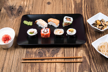 fresh Japanese tasty sushi roll set with chopsticks on wooden table