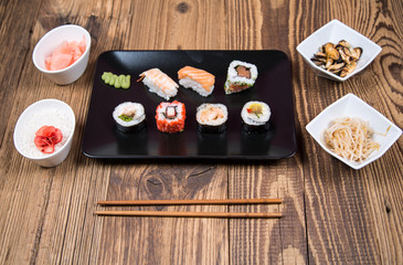 fresh Japanese tasty sushi roll set with chopsticks on wooden table