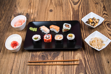 fresh Japanese tasty sushi roll set with chopsticks on wooden table
