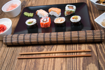 fresh Japanese tasty sushi roll set with chopsticks on wooden table