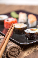fresh Japanese tasty sushi roll set with chopsticks on wooden ta