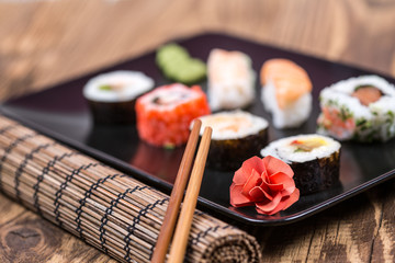 fresh Japanese tasty sushi roll set with chopsticks on wooden ta