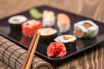 fresh Japanese tasty sushi roll set with chopsticks on wooden ta