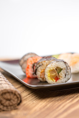 fresh Japanese tasty sushi roll set with chopsticks on wooden ta