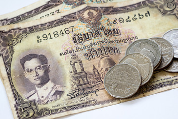 Thailand old money banknotes with five baht coin in use currentl
