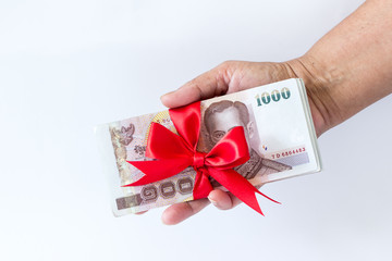 Woman hand holding and give Thailand money banknotes on white ba