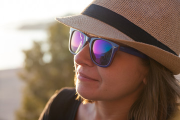 Young woman in a hat and sunglasses