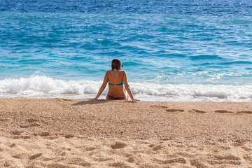 Fototapeta na wymiar Young woman resting on the beach Kaputash, Turkey