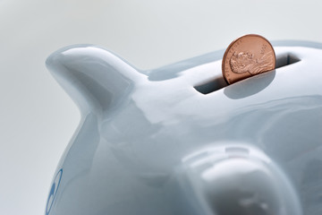 blue piggy bank and a coin falling in it