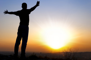 Fototapeta premium man arms outstretched to the side at sunset