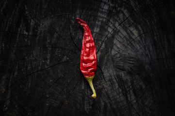 Hot red pepper lies on a dark board