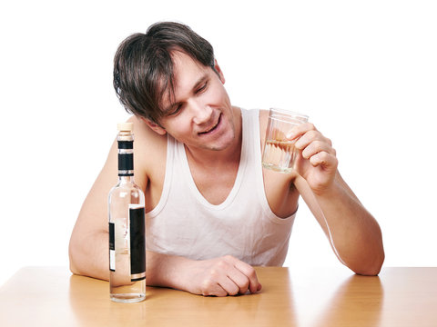 Drunk man with bottle of vodka and glass