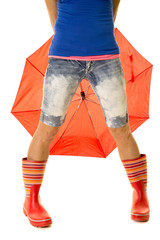 woman legs in rain boots in front of umbrella