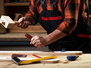 Close up of senior carpenter working in his workshop with chisel and hammer.