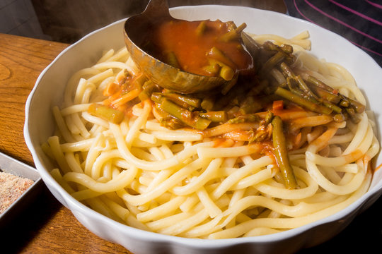Versamento sugo sulla pasta cotta scolata